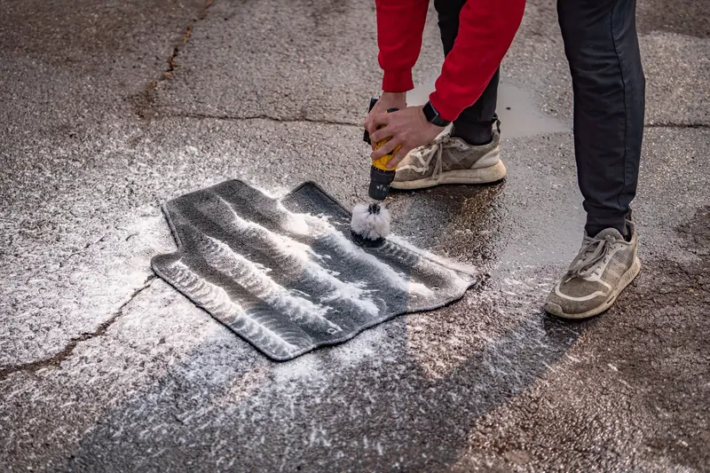 Cleaning floor mats on the driveway